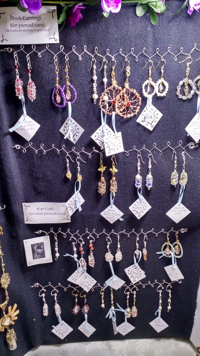 Close-up of earrings and ear cuffs hanging on the display.